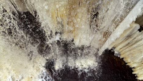 Waterfall-with-icicles-in-close-top-down-view-in-winter