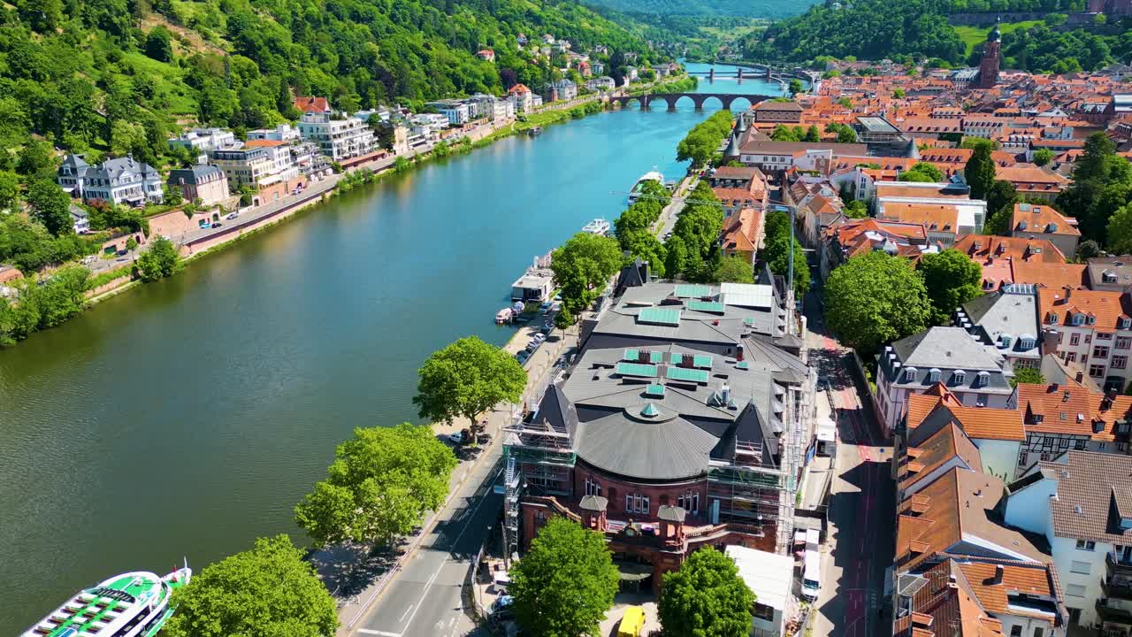 Video aereo con drone 4K di case storiche, negozi e chiese lungo il fiume Neckar nel centro di Heidelberg, Germania