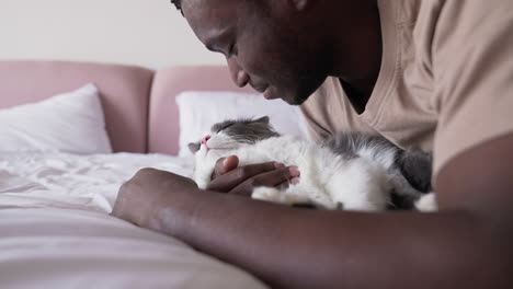 dueño de mascota con su gato en la cama