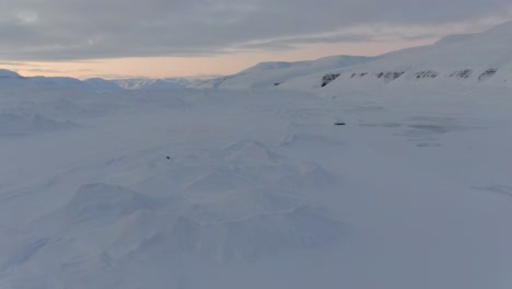 Drohnenansicht-In-Spitzbergen,-Die-An-Einem-Bewölkten-Tag-über-Schneeweiße-Berge-Mit-Zugefrorenen-Seen-In-Norwegen-Fliegt