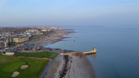 aerial static of sunset light over blackrock diving board salthill, galway, people enjoying the atlantic coastline and promenade in ireland
