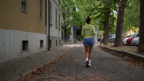 woman running down a city street in autumn