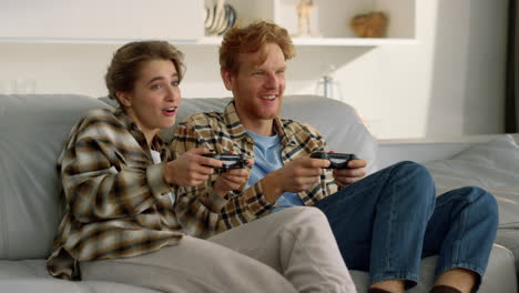 friends playing video game in living room. happy family couple enjoy competition