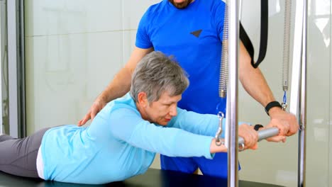 entrenador ayudando a una mujer mayor en la realización de yoga 4k