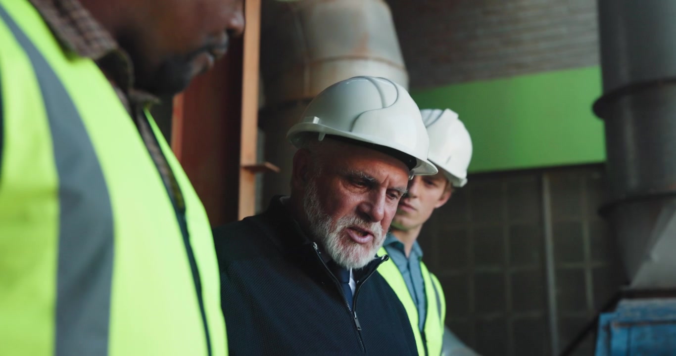 Construction Managers Discussing Project Plans at Industrial Site