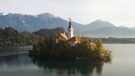 epic cinematic aerial footage of the pilgrimage church of the assumption of mary, surrounded by water