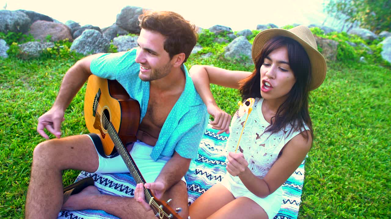 보호 옷 을 입은 다민족 부부 가 피크닉 을 즐기고 있다