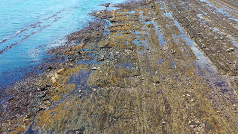 Clip-De-Un-Vuelo-De-Drones-De-La-Playa-En-St-Monans-Mientras-La-Marea-Estaba-Baja,-Mostrando-La-Arena,-El-Barro-Y-El-Mar