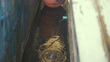 El-Agua-Que-Se-Bombea-Fuera-De-La-Sentina-En-Un-Bote-De-Madera