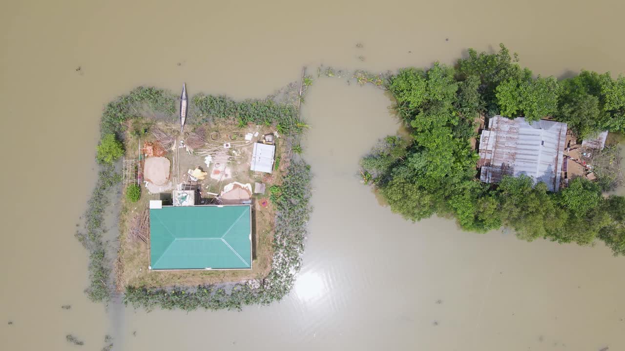 Aerial view of flood affected houses surrounded by muddy water and trees in Bangladesh, South Asia