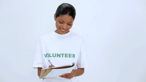 smiling volunteer woman thinking and writting on notebook