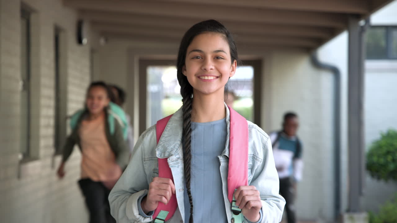 Smiling girl with backpack standing in school hallway, feeling happy and confident, copy space