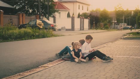 cansado de estudiar los niños tiran el libro en la carretera de asfalto gris