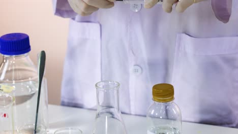 el científico lleva a cabo el experimento de cambio de color azul de bromotimol