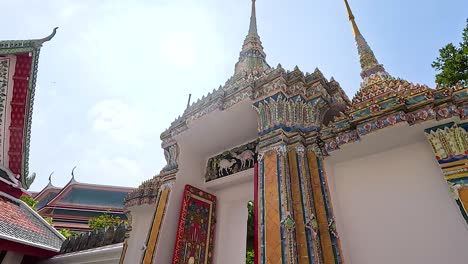 a visitor explores the ornate architecture of wat pho under bright daylight, capturing the temple's intricate details and vibrant colors
