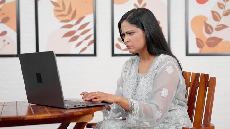 ernsthafte frau arbeitet an einem laptop