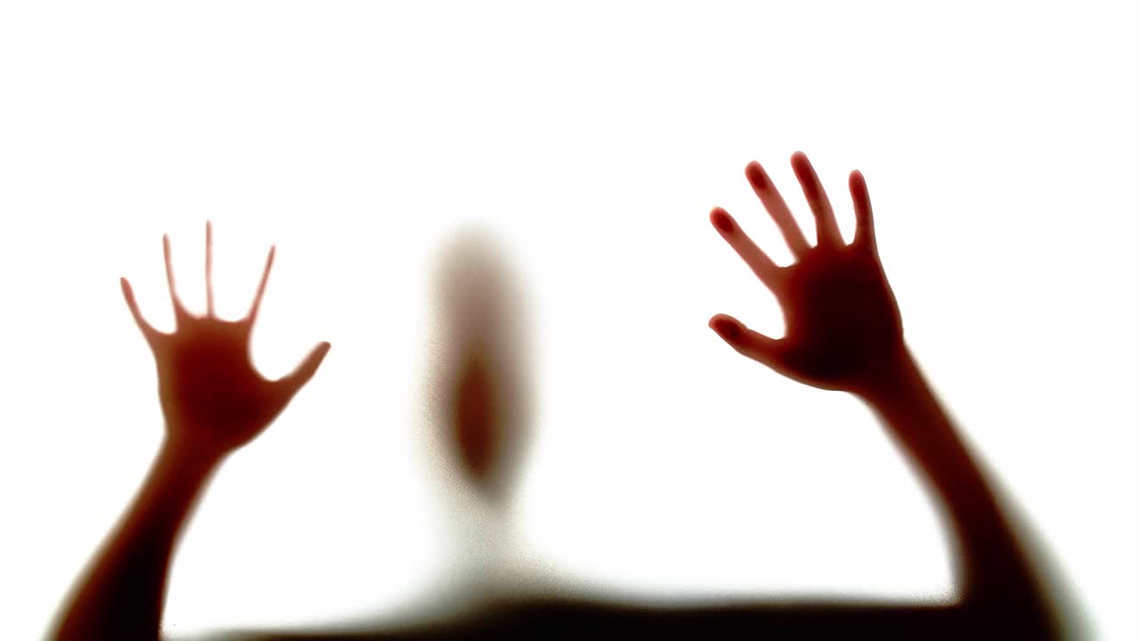 Silhouette of Hands Reaching Through a Window