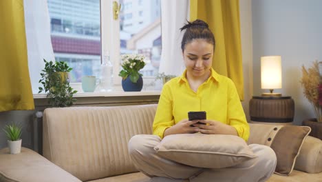 Young-woman-texting-with-happy-expression.