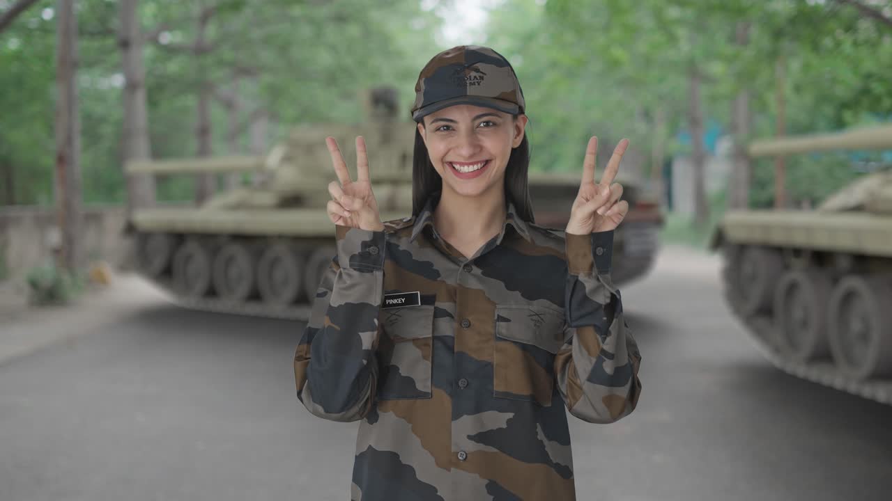 feliz mujer india oficial del ejército mostrando el signo de la victoria