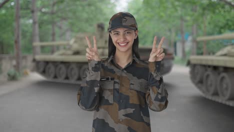 happy indian woman army officer showing victory sign