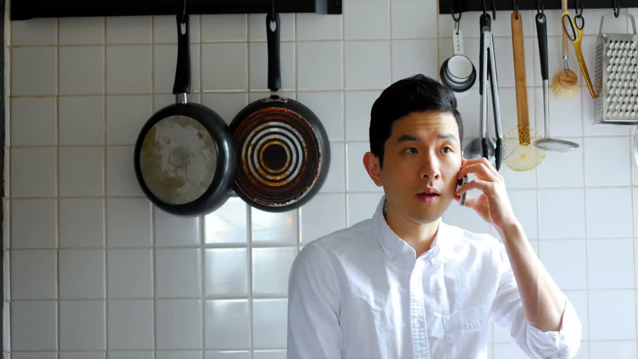 주방 4k에서 휴대 전화로 이야기하는 남자