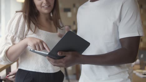 caucasian and african american coworkers using tablet