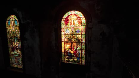 glass-stained windows inside dark abandoned saint-eusèbe-de-verceil church after fire in montreal canada. zoom in shot