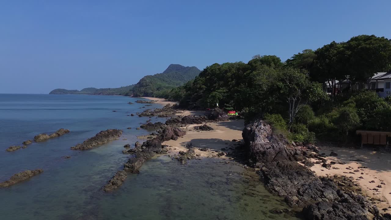Ripresa con drone di una costa rocciosa a Koh Jum, conosciuta anche come Koh Pu, a Krabi, Thailandia, con giungla tropicale, acqua cristallina dell'oceano e una montagna suggestiva che creano un paesaggio costiero incontaminato e selvaggio senza persone.