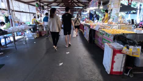 people walking around a vibrant market alley