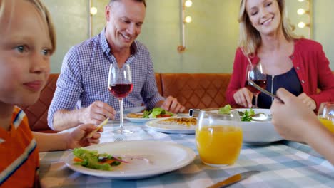 family having meal together in restaurant 4k