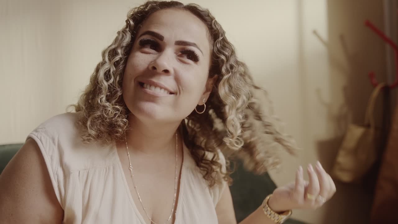 A woman with curly hair styling or examining her hair