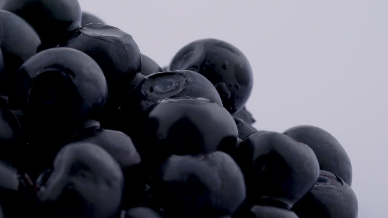 супер близкий макрос голубых ягод, вращающихся на пластинке, изолированный на белом фоне.