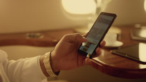 manager looking smartphone charts on corporate trip. closeup hands hold phone