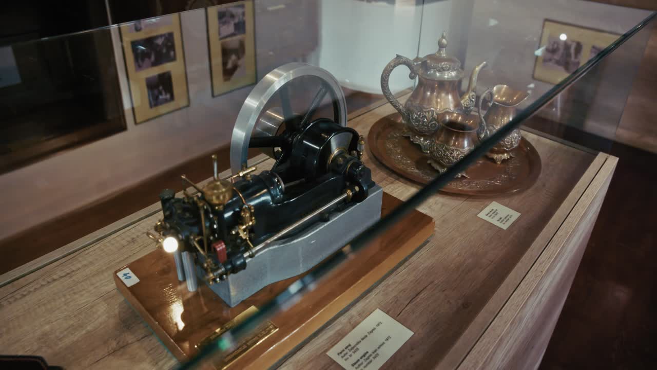 Display of a vintage engine model and ornate tea set in Kumrovec museum, Croatia