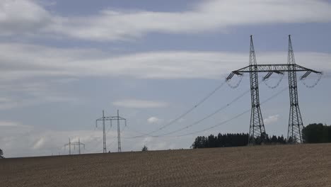 large view on the powerlines on the field. high voltage post or high voltage tower in field.