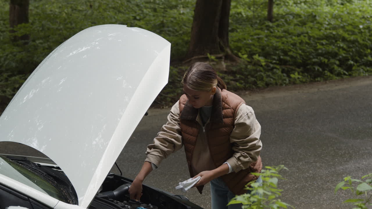 Woman examining car engine