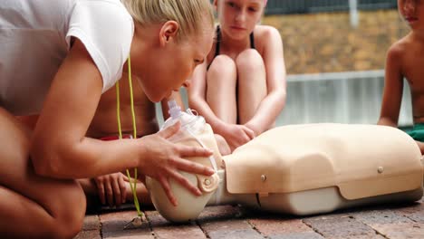 swim coach training students on dummy