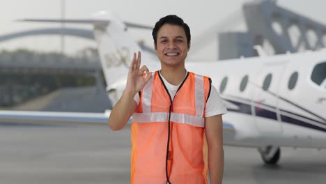 Happy-Indian-airport-ground-staff-showing-Okay-sign