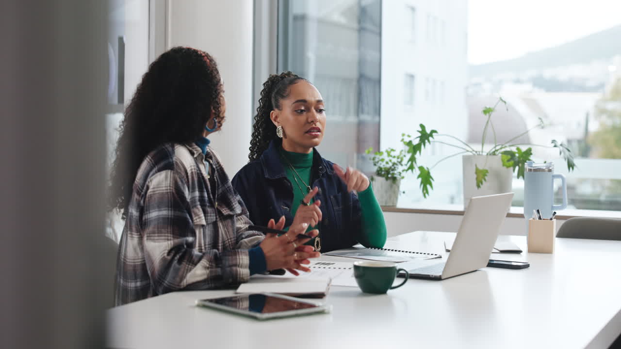 Due donne che partecipano a una riunione di lavoro in ufficio