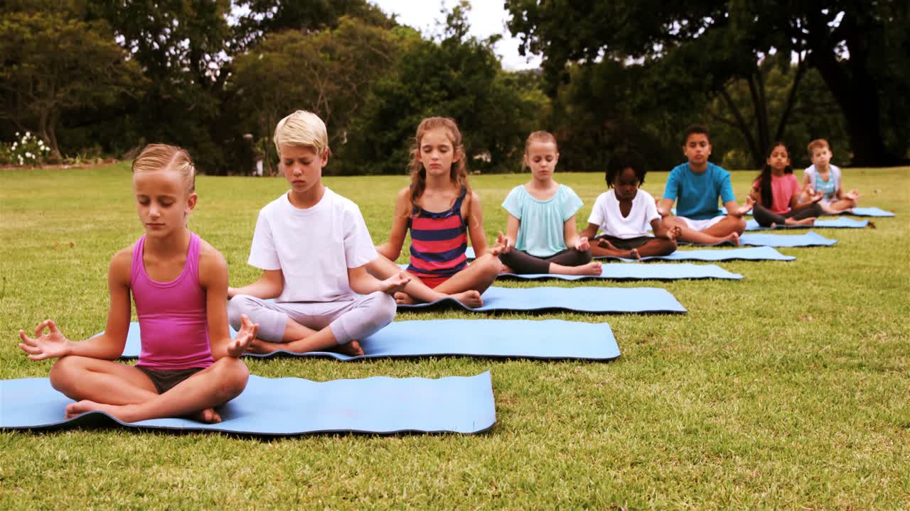 grupo de niños realizando yoga en el parque