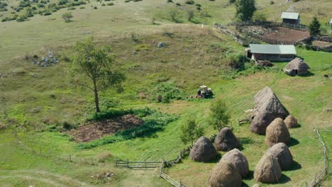 aerial: arc shot of old farm buildings, remote serbian hillside