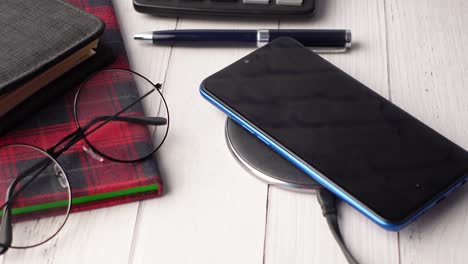 smartphone wireless charging on wooden desk