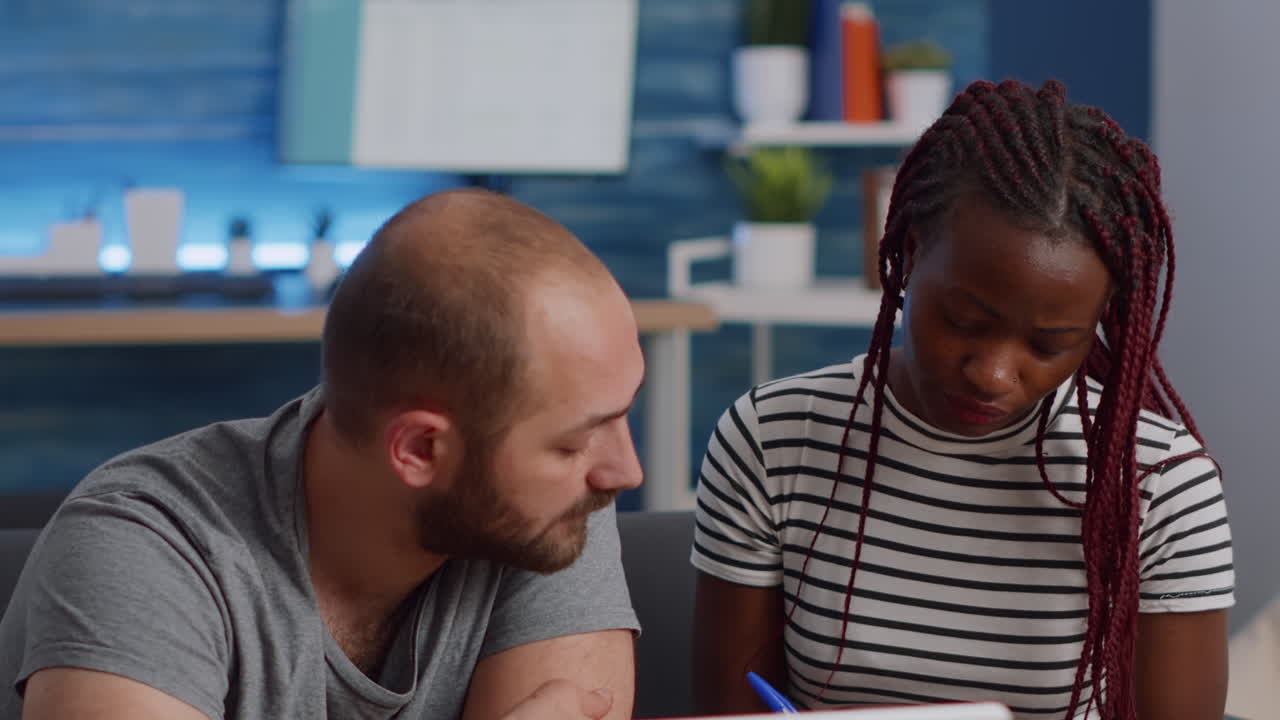 Young interracial couple paying taxes with laptop in living room