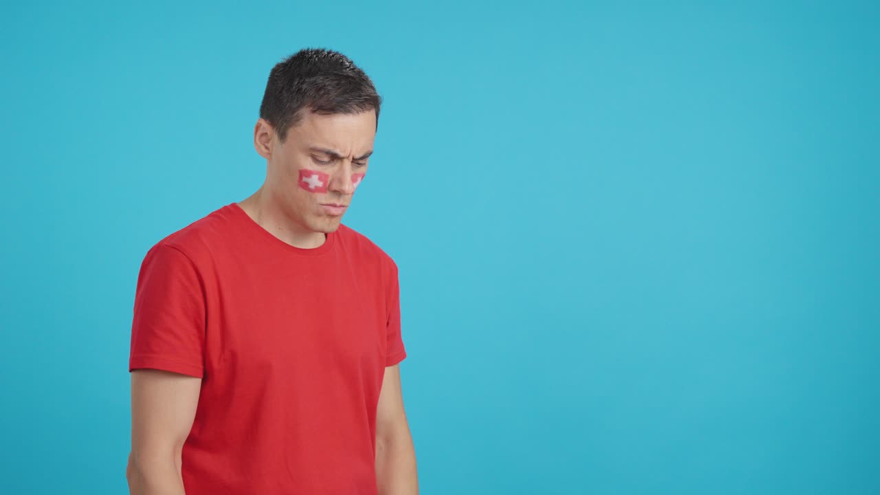 Man with swiss flag painted looking away with serious expression