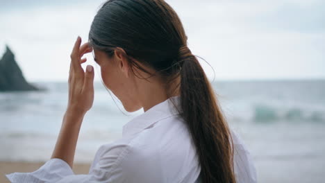 tranquil woman standing seacoast in front ocean waves close up. girl relaxing.