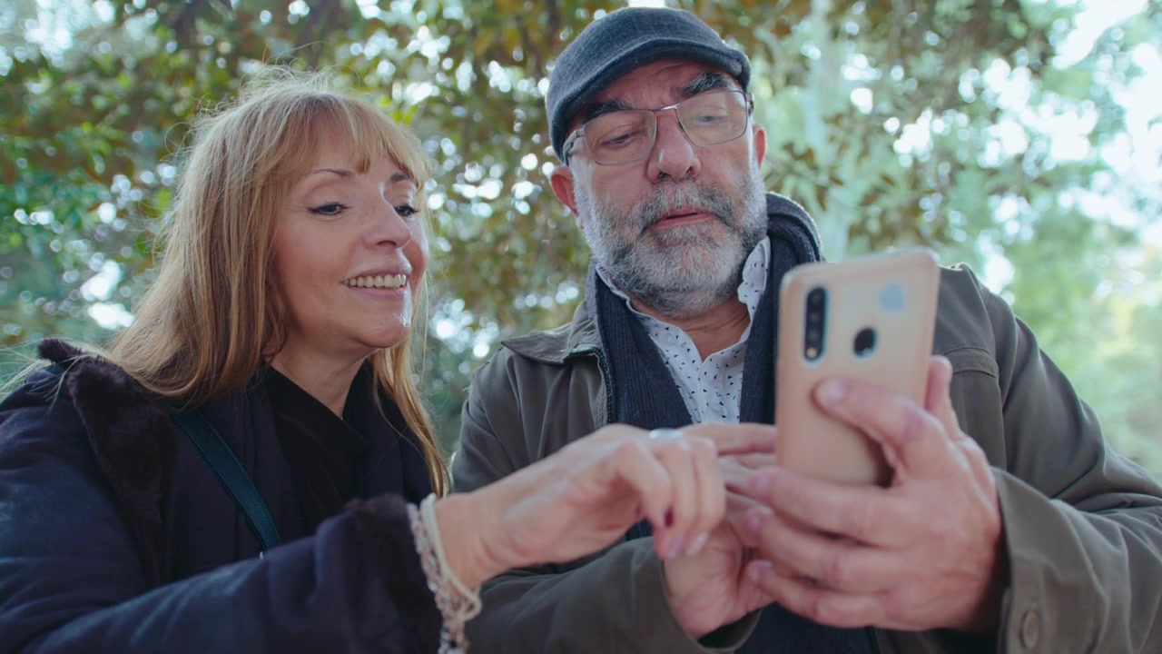 Coppia anziana che consulta una mappa sullo smartphone all'aperto nel parco
