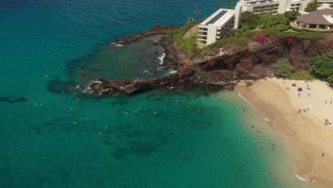 Vista-Aérea-Giratoria-De-Buceadores-En-Black-Rock-Frente-Al-Hotel-Sheraton-En-La-Playa-De-Kaanapali-En-Maui-Hawaii