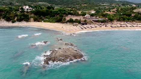 waves of azure water crashing in towards rocks and beautiful beach with amazing resort