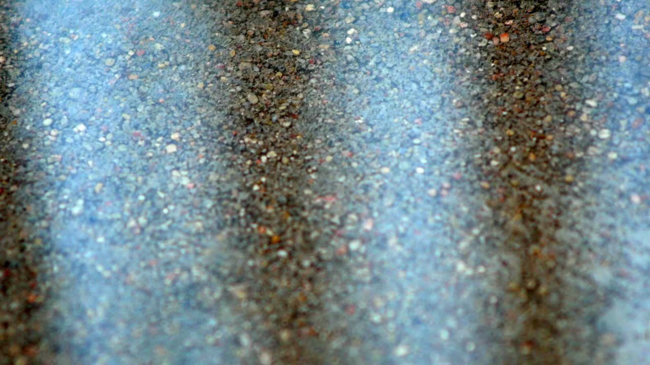 las gotas de lluvia caen al agua en la carretera de hormigón y se salpican