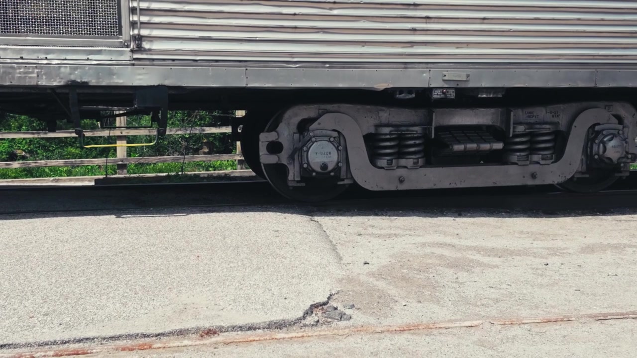 A close up of train wheels on the track, arriving at a train station